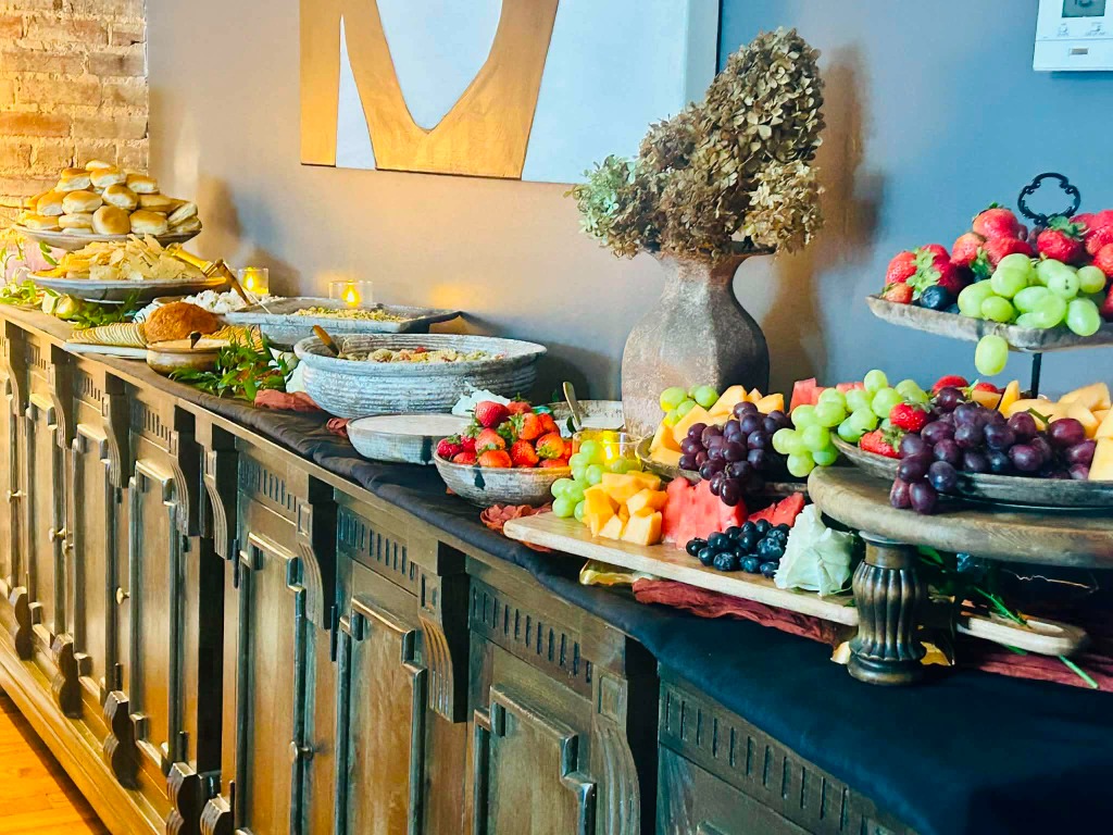 Beautifully arranged catering spread with fresh fruit, dips, and breads